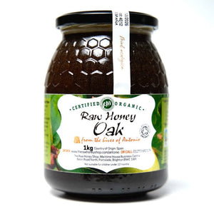 Jar of dark Oak honey with white label to the front of the jar with the wording Raw Honey Oak.