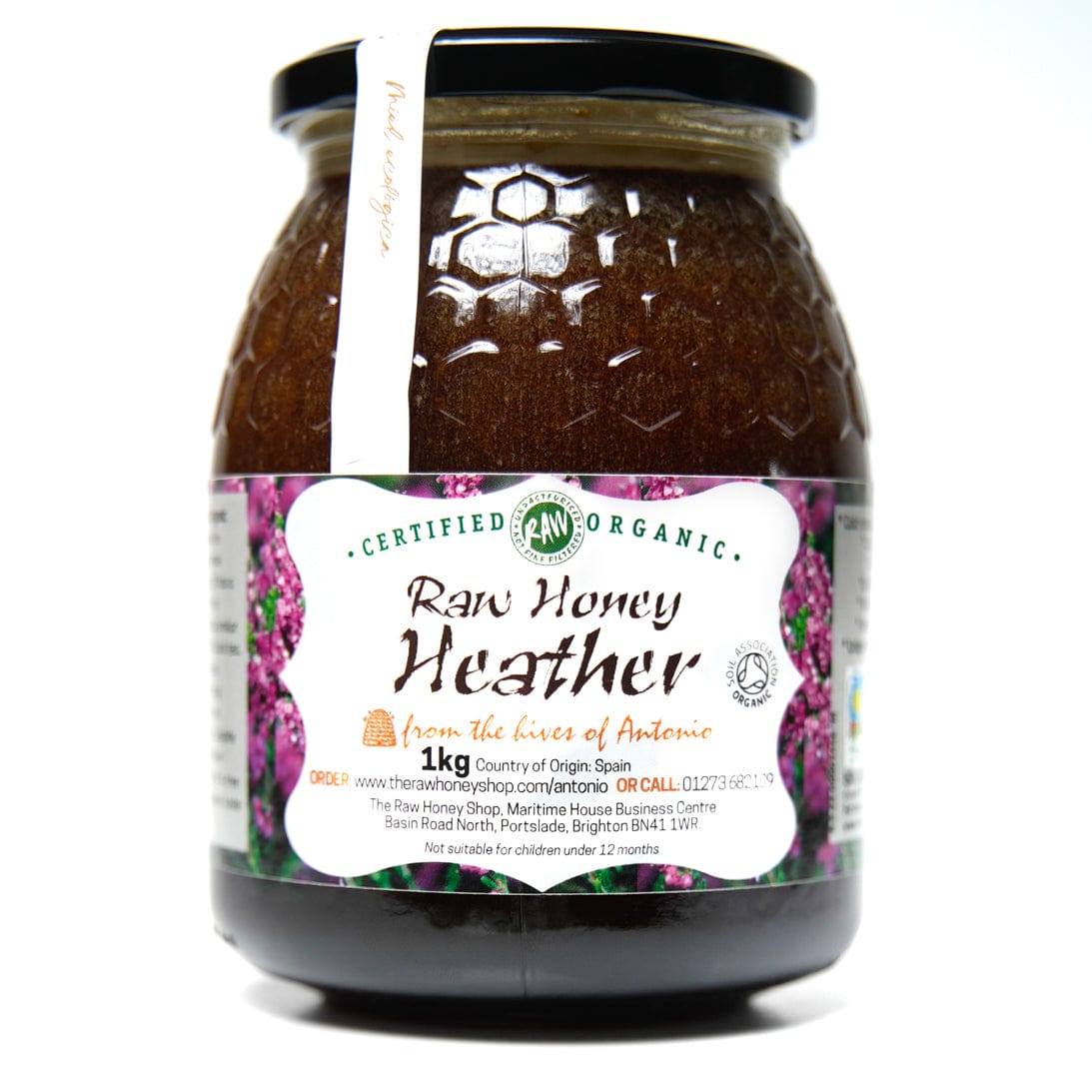 Jar of dark Heather honey with white label to the front of the jar with the wording Raw Honey Heather.