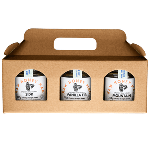Three jars of Raw Honey Man honey in a cardboard carrier on a white background