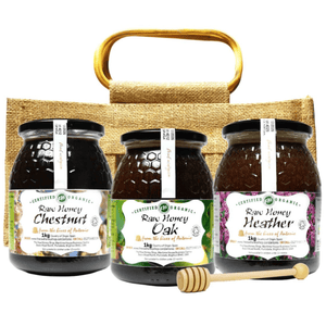 Three jars of raw honey with labels on a jute bag with a wooden handle.