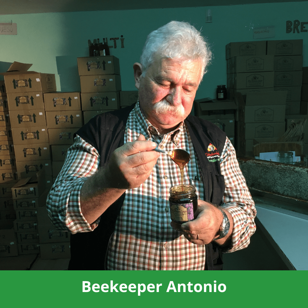 Beekeeper Antonio holding jar of organic oak honey.