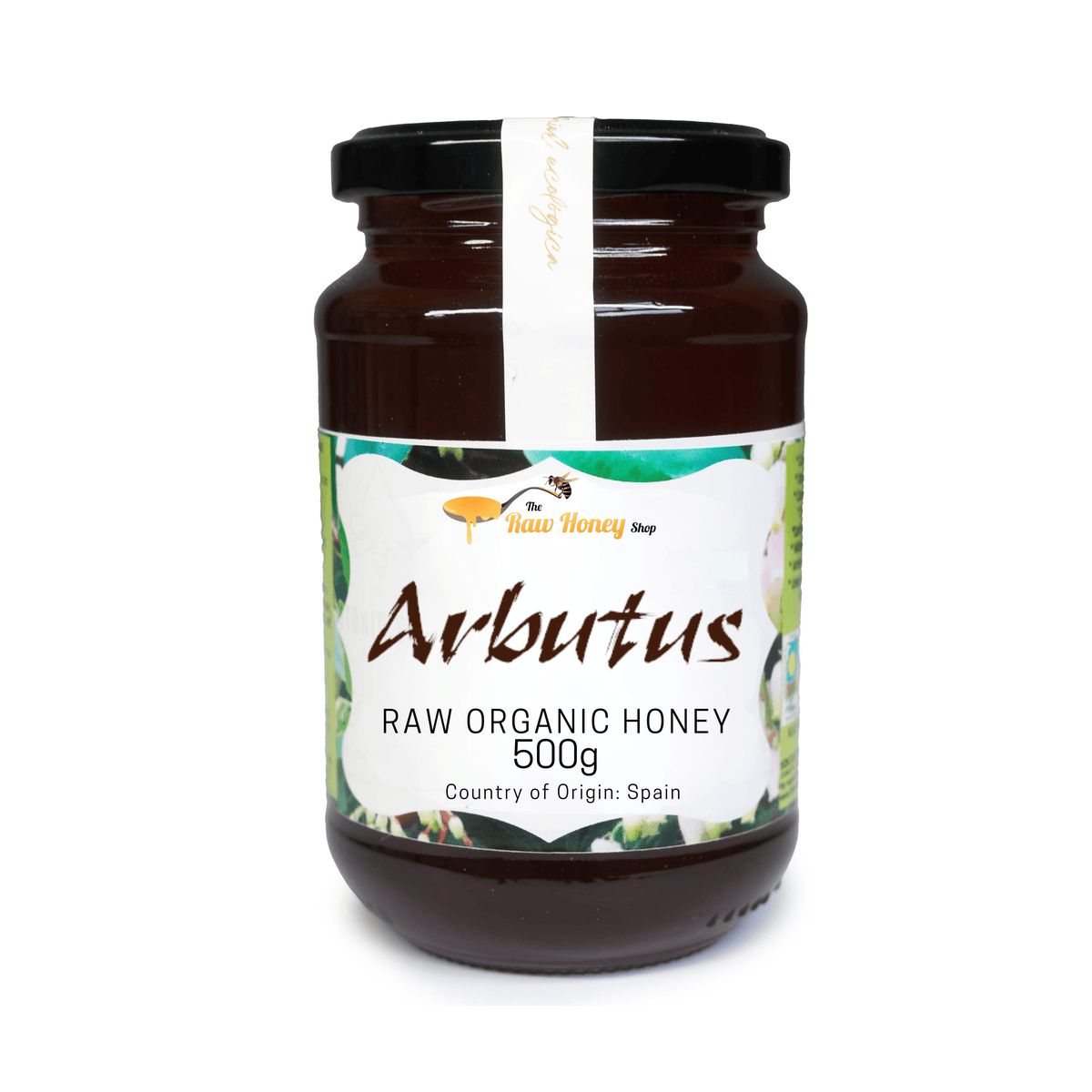 A 500g glass jar of Raw Organic Honey from The Raw Honey Shop with a black lid and a white label featuring green and yellow illustrations, set against a plain white background.