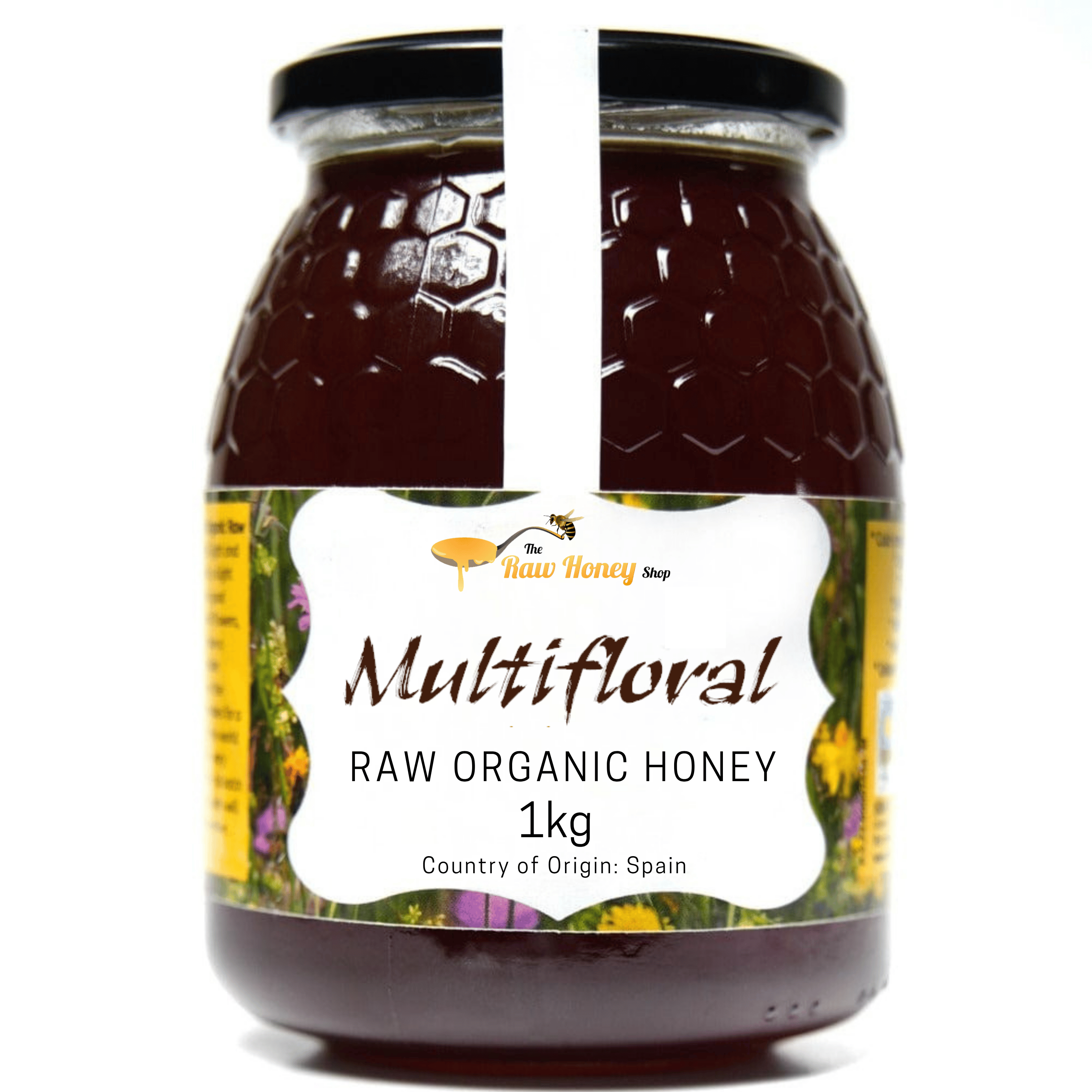 A 1kg glass jar of Antonios Multifloral Raw Organic Honey from The Raw Honey Shop. On a white background, with a vertical white stripe running down the center of the glass.