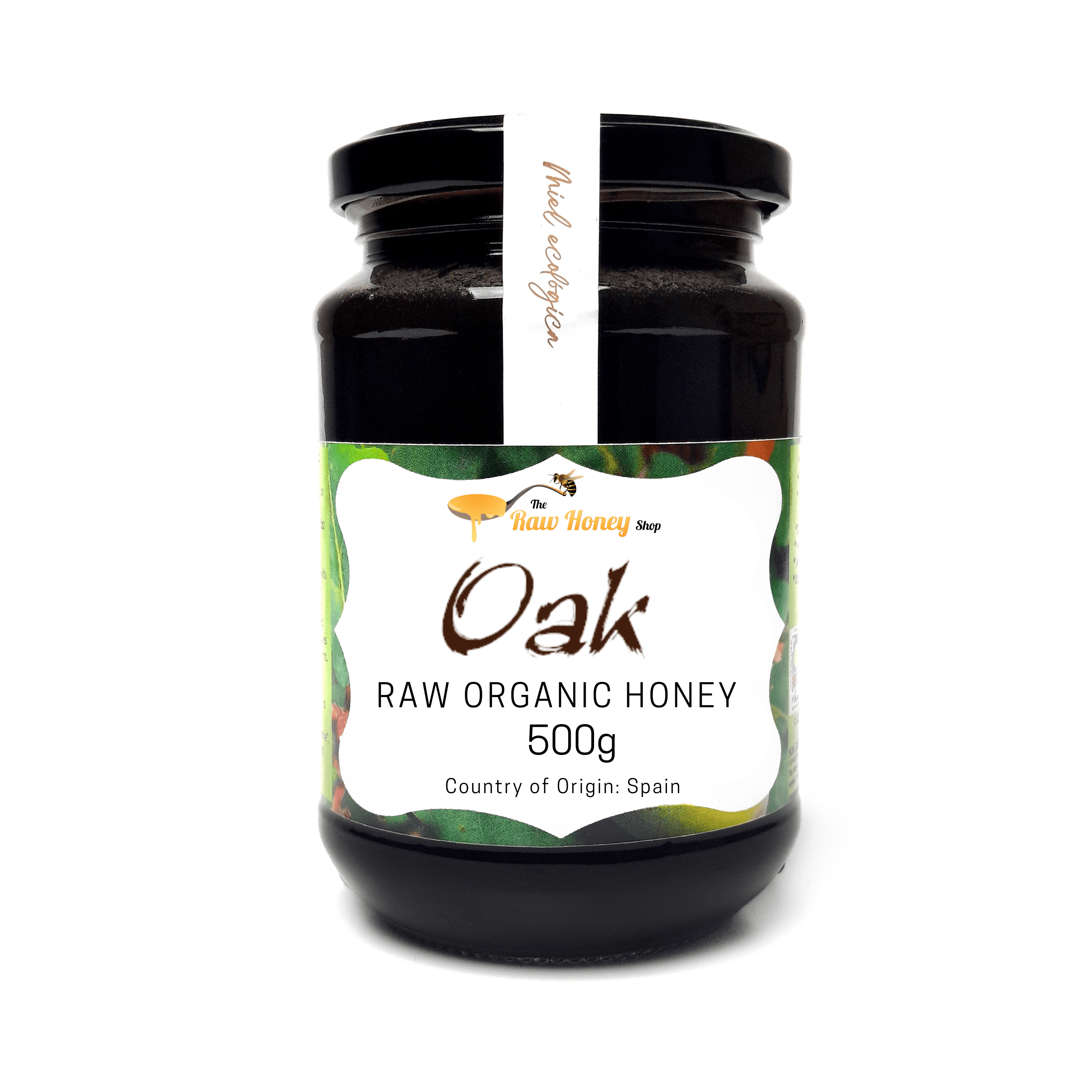 A 500g glass jar of Antonios Oak Raw Organic Honey from The Raw Honey Shop, featuring a black lid, a white vertical label, and a green and white decorative front label.