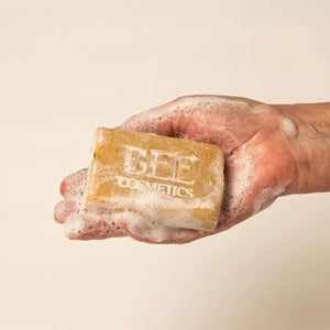 Hand holding a bar of lathered up Bee Cosmetics' Soap.