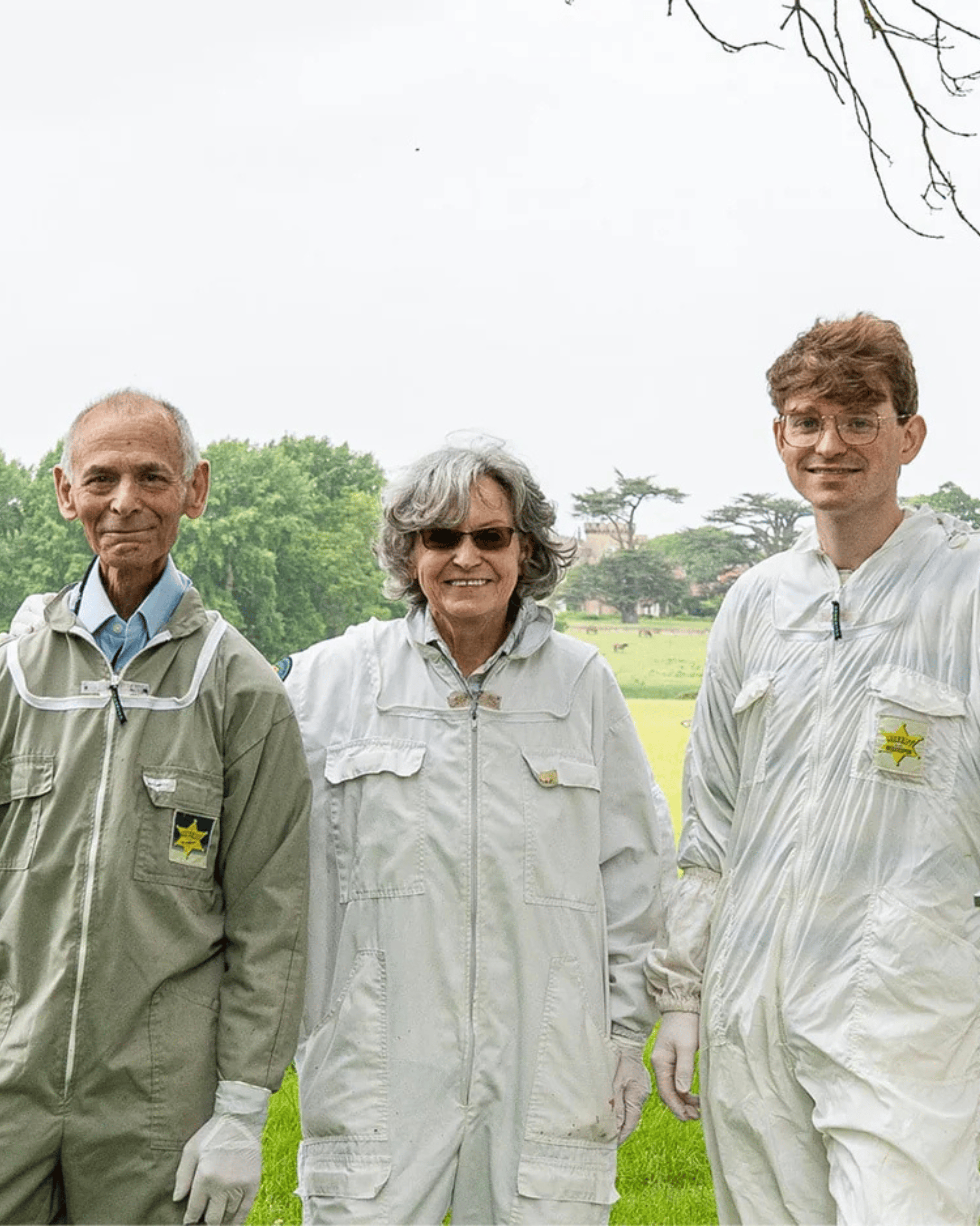 The Bee Cosmetics family - mother, husband and son wearing beekeepers outfits.