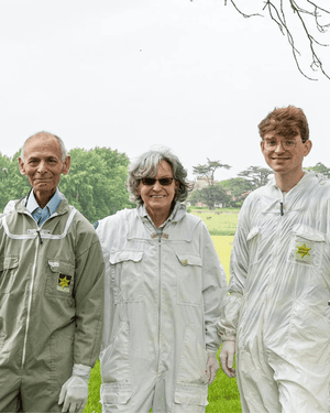 The Bee Cosmetics family - mother, husband and son wearing beekeepers outfits.