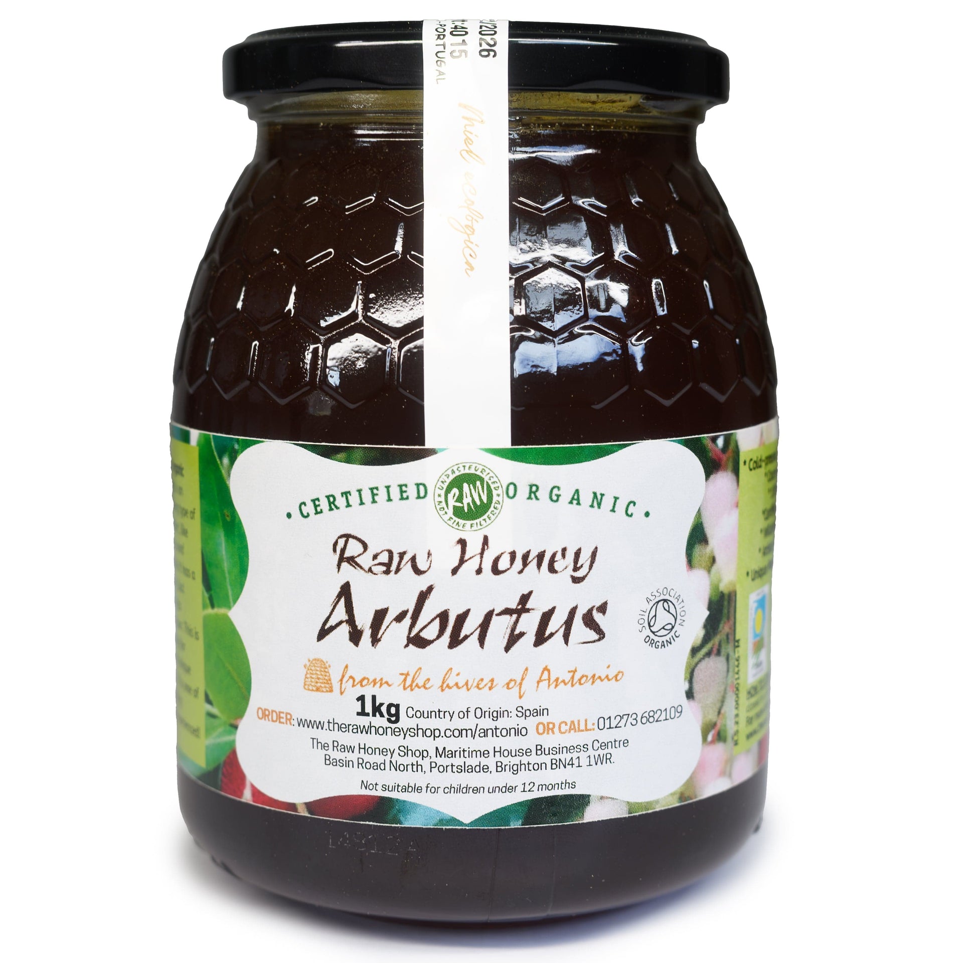 Glass jar containing very dark brown honey with label to the front of the jar which reads Certified Organic Raw Honey Arbutus.