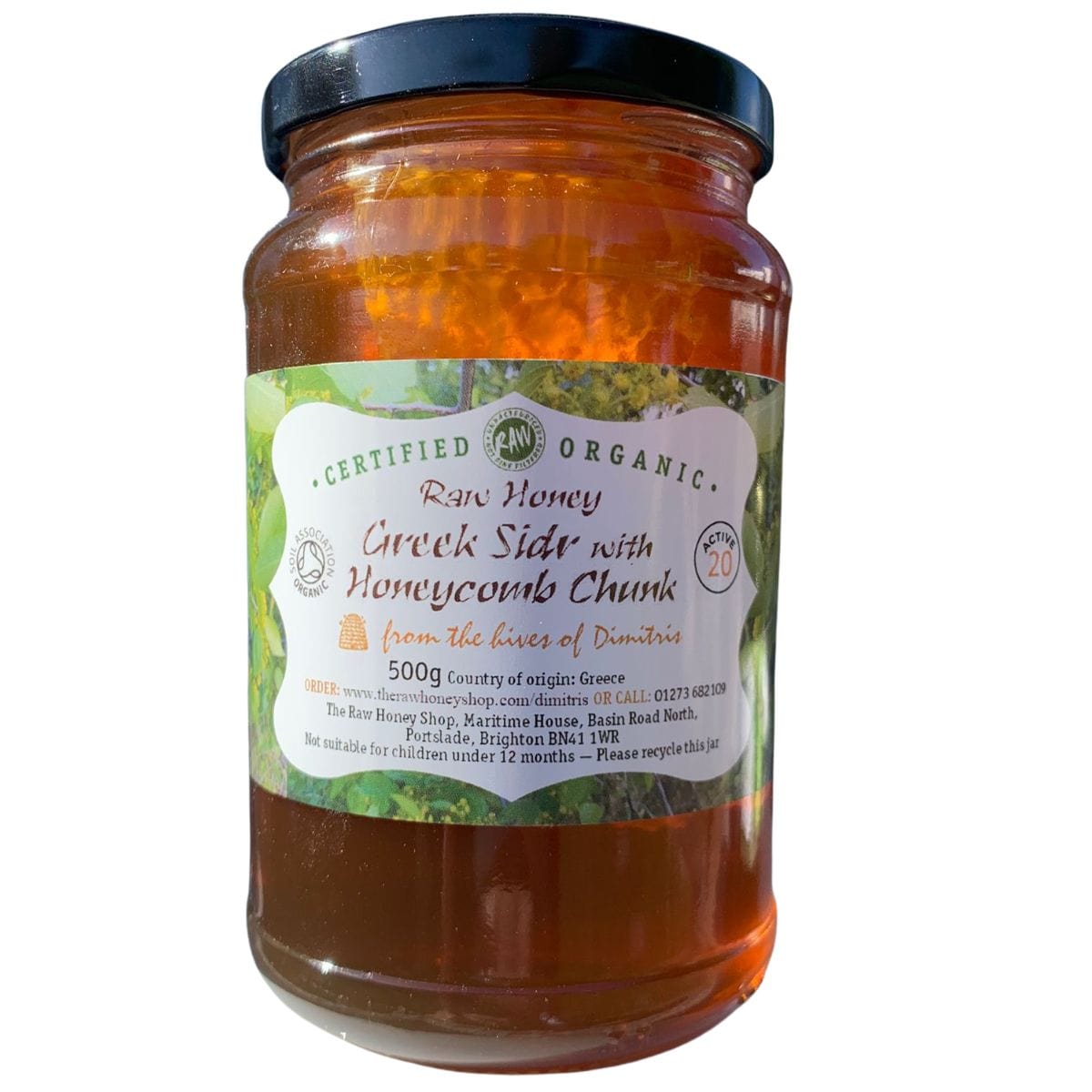 Jar of raw honey with a label on a white background