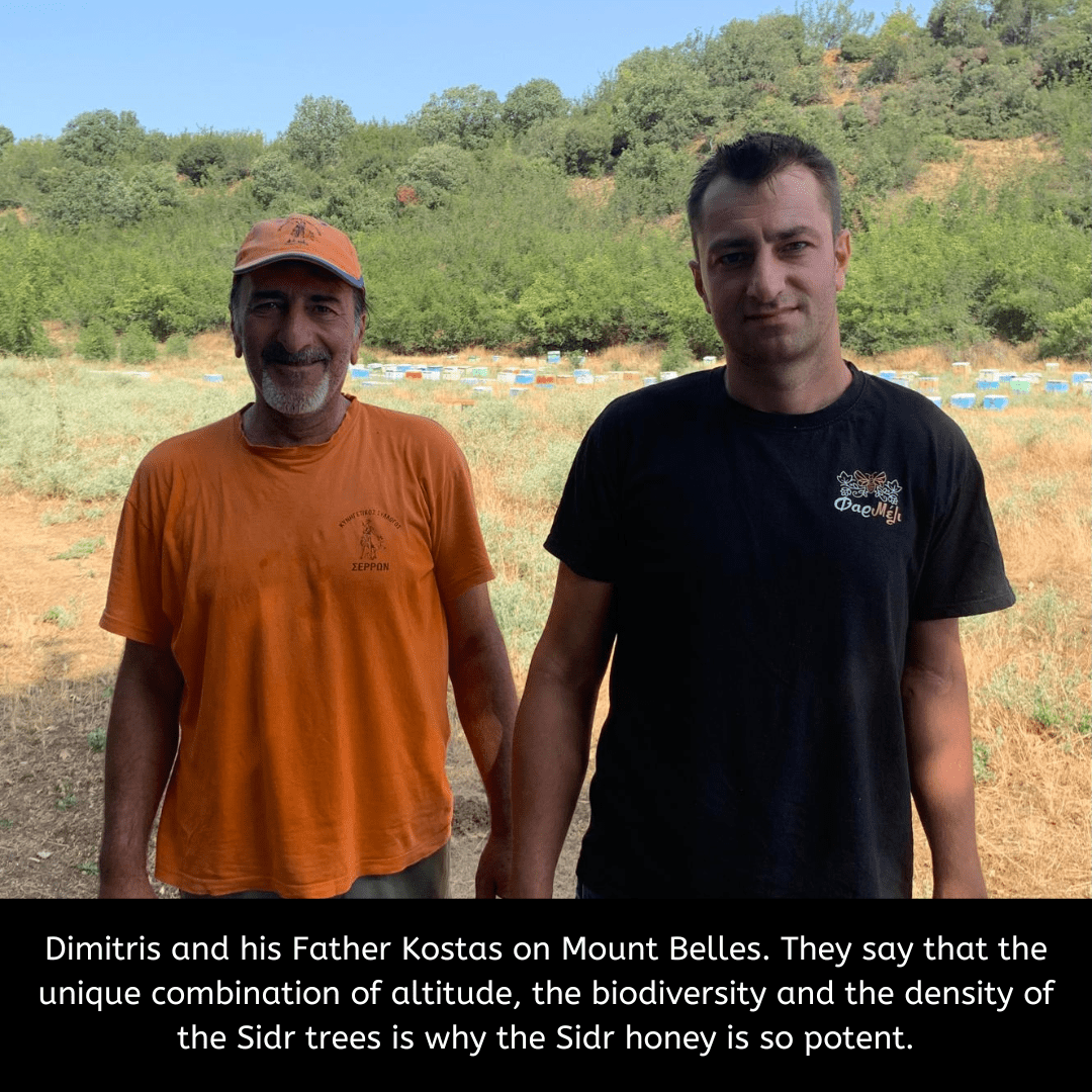 Two men standing on a field with trees in the background, discussing Sidr honey.