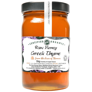 Light orange coloured honey in glass jar with white label to front.