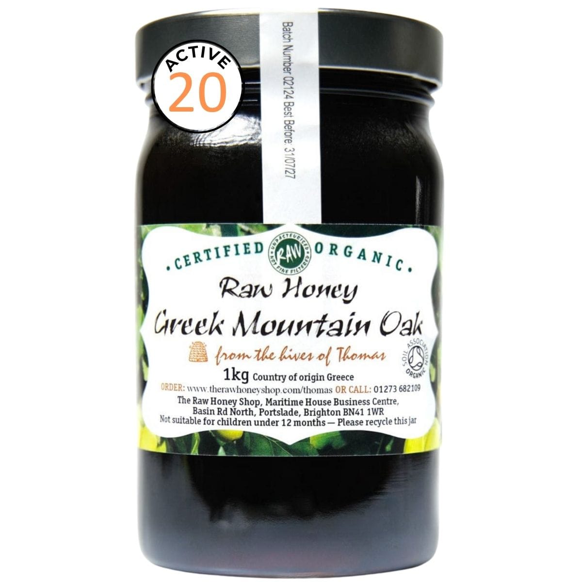 Very dark brown honey in a glass jar with a white label to the front of the jar