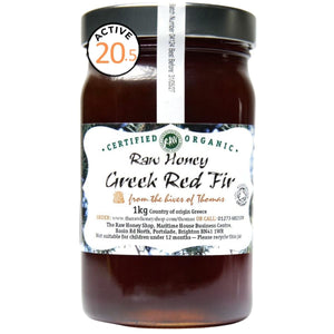 Jar of brown honey with white label to the front