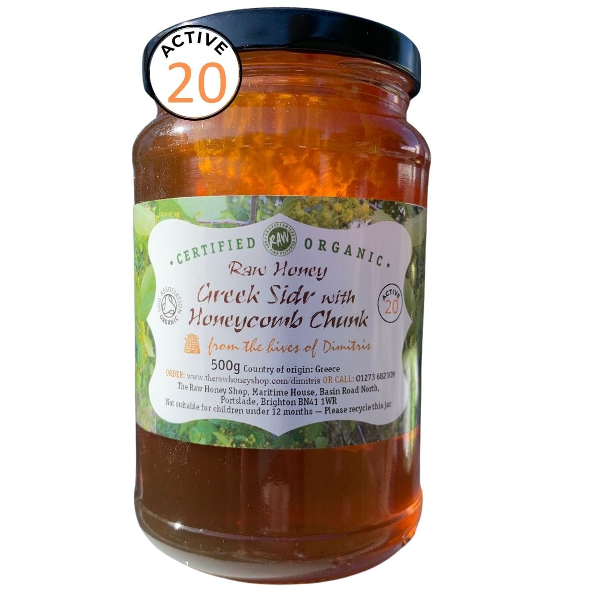 Jar of raw honey with a label on a white background