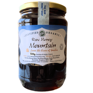 Jar of raw honey with a label on a white background