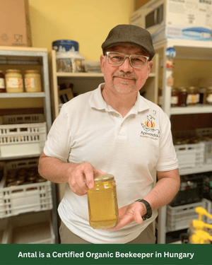Beekeeper Atal holding a jar of his raw organic Acacia honey.