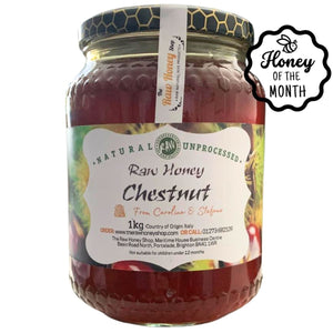 Jar of chestnut honey with a label on a white background, featuring 'Honey of the Month' branding.