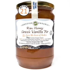 Jar of raw honey with a label on a white background