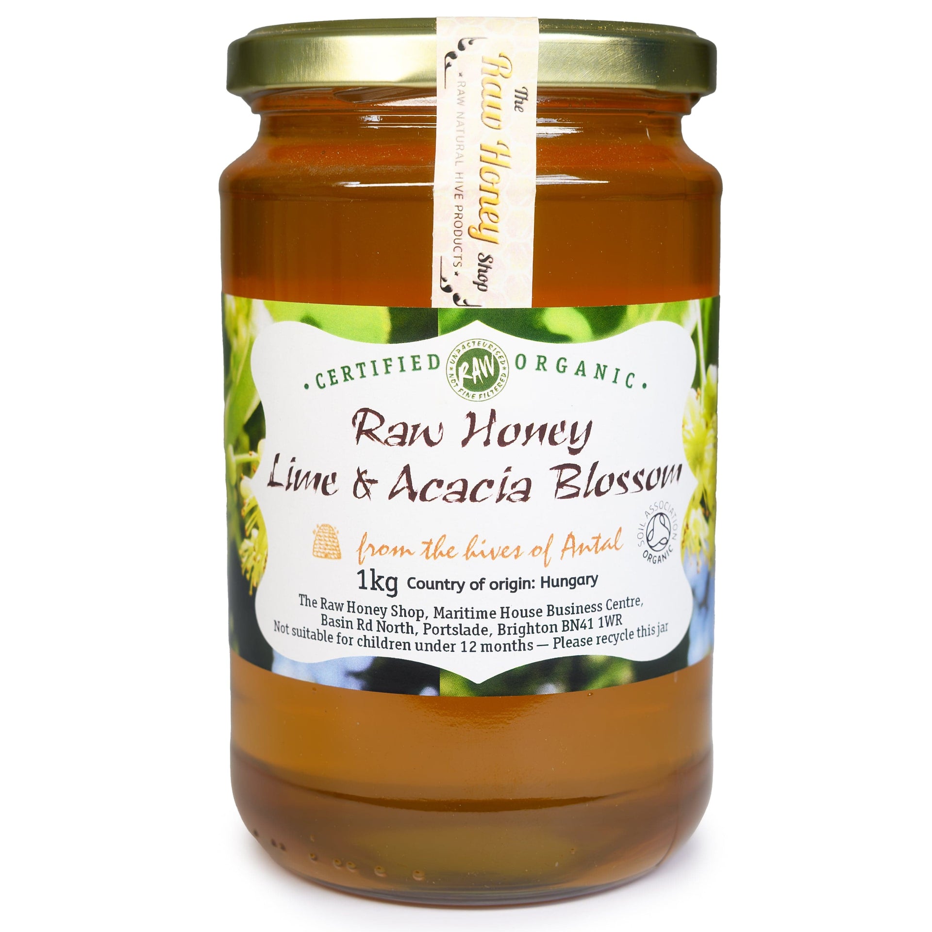 Glass jar containing light amber coloured honey with a Lime and Acacia Blossom label at the front of the jar.