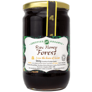 Black honey in a glass jar with a white label,
