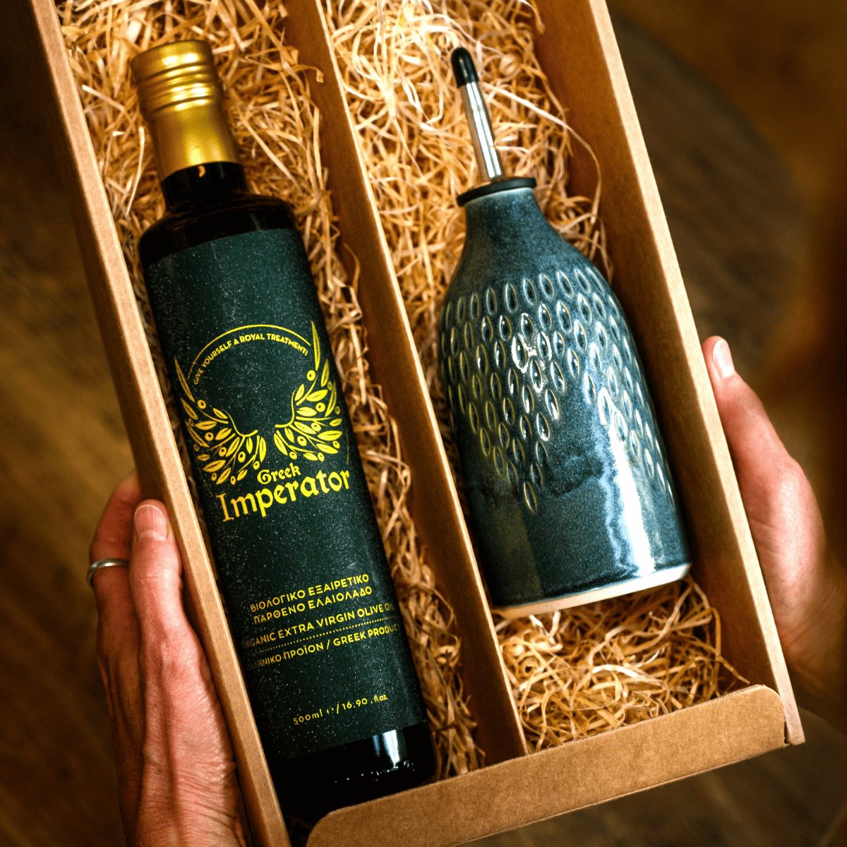 olive oil bottle in a box with one labeled 'Grand Imperator' and the other decorative olive oil pourer.