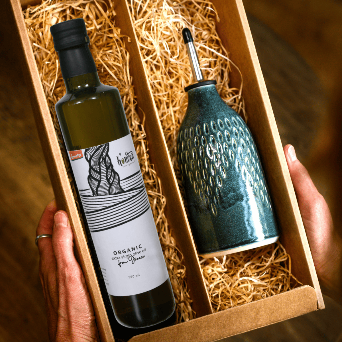 Bottle of organic olive oil with a decorative olive oil pourer in a gift box.