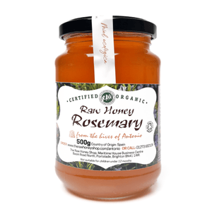 Jar of raw honey rosemary with a label on a white background