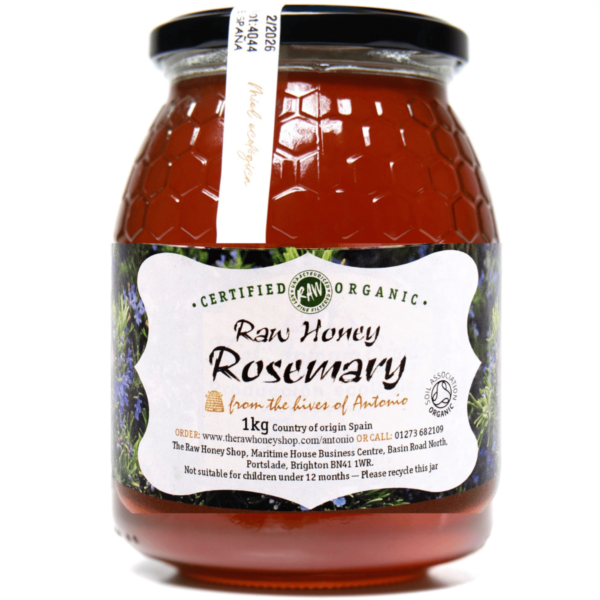 Jar of raw honey rosemary with a label on a white background