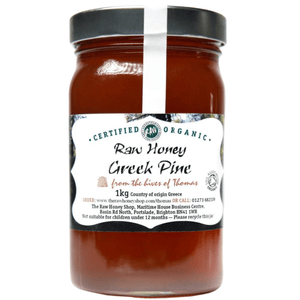 Jar of raw honey with a label on a white background