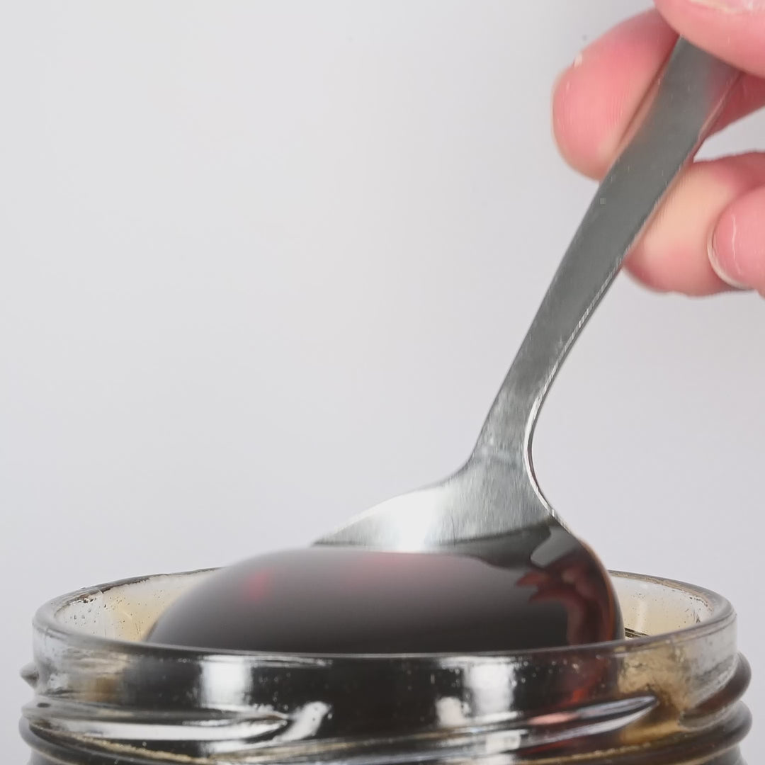 Raw Mountain Honey being poured from a spoon.
