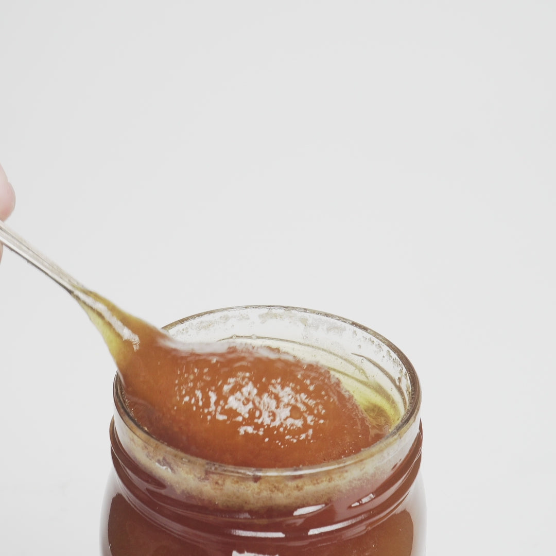 video of spoon dripping into an open jar of raw organic Greek thyme honey.