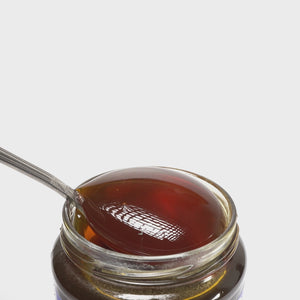 video of metal spoon covered in honey pouring into an open jar of raw organic Mount Olympus Mountain honey.