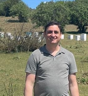 Beekeeper Dimitris standing infront of his hives.