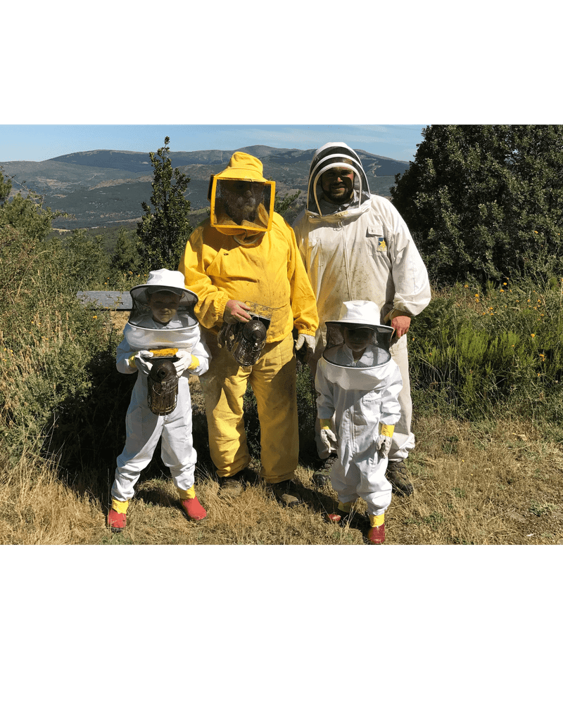 Family of four wearing beekeeper suits, comprising two adults and two children.